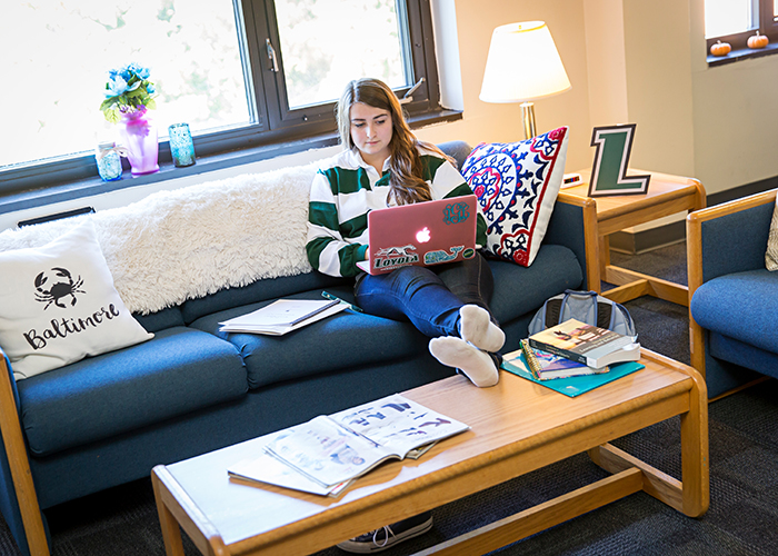 Student sitting on couch in residence hall 