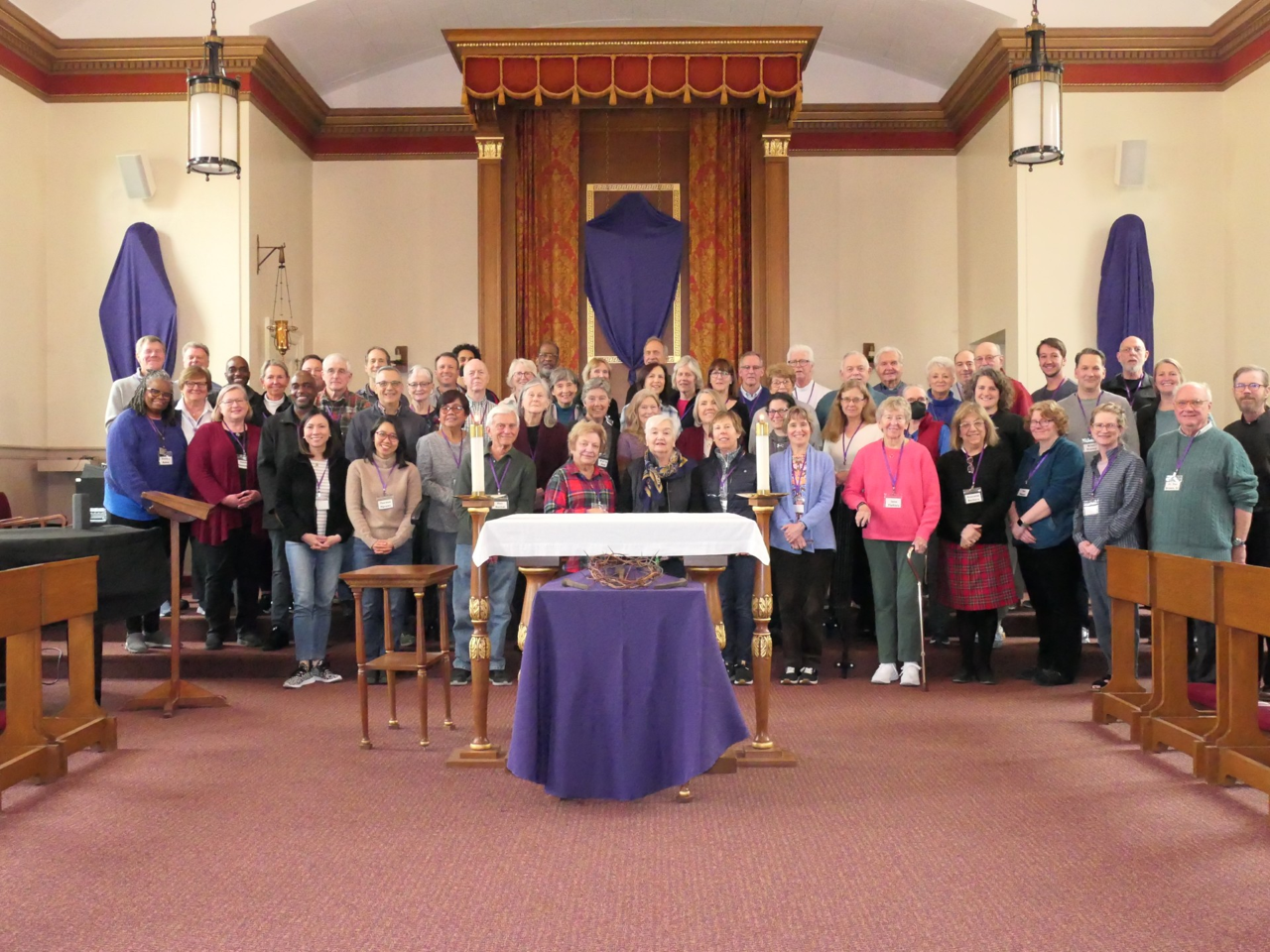 A group photo of retreat participants and leaders, gathered together in the front of a church