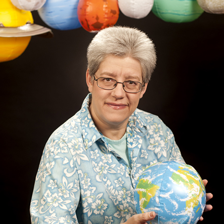 Inge Heyer photo portrait with air-filled planetary models above her.