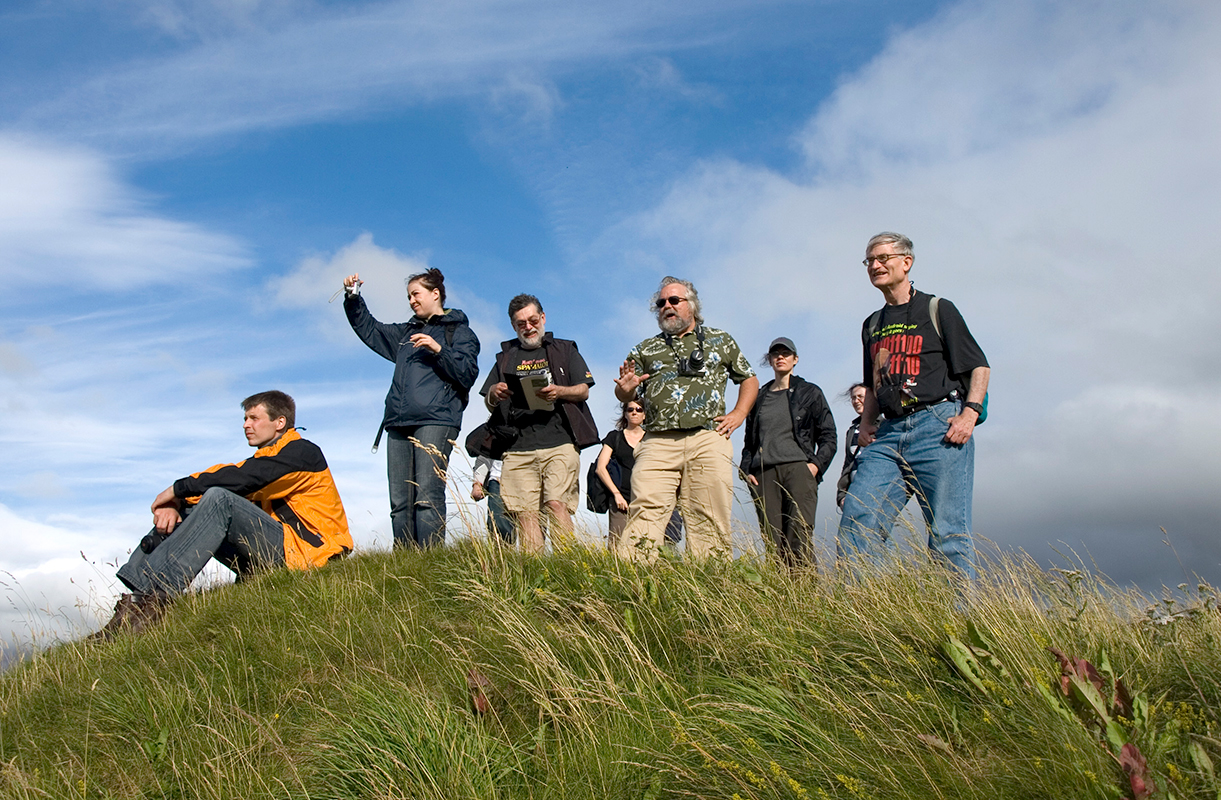 Kelly Devries and others standing atop a green grassy hill