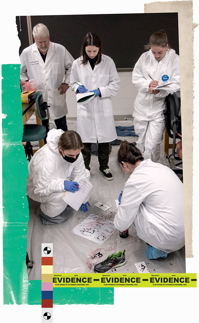 Students in white lab coats and hazmat suits take notes while scrutinizing simulated blood spatter on the floor
