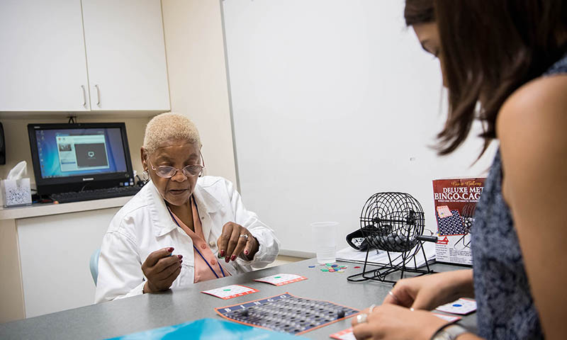 Two women playing Bingo in a clinical setting