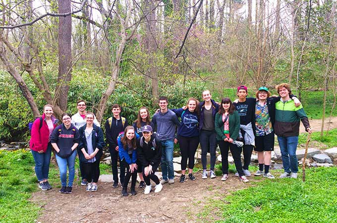 An honors class posing for a group photo in the middle of a hike