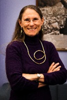 Dr. Amanda Konradi arms folded in a purple sweater.