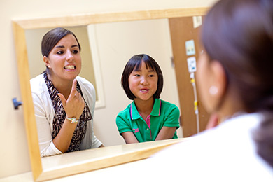 Speech-language pathology student working with a child