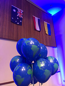 Balloons that look like globes floating in front of various flags from different countries