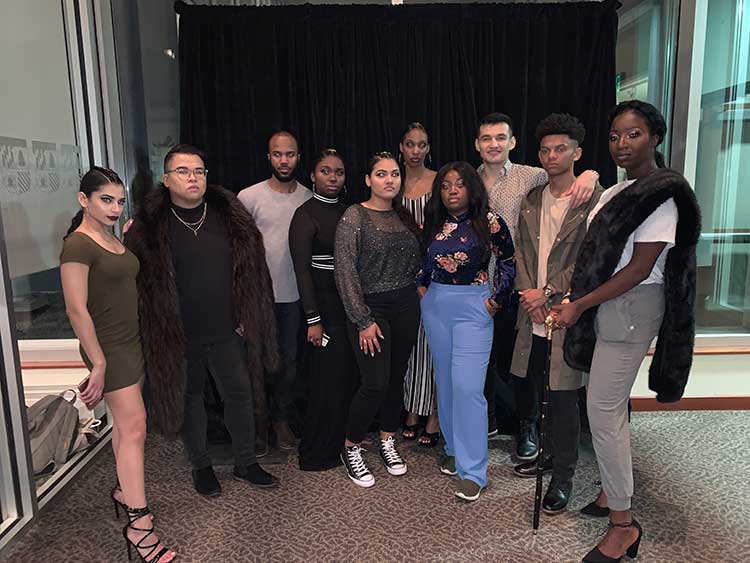 A group of student models posing back stage the night of a show