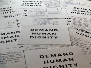 postcards with the words 'demand human dignity' printed on them