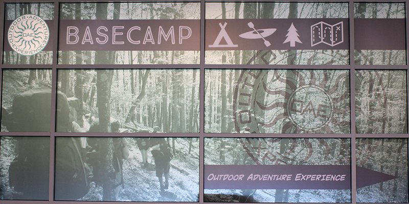 The entry to Outdoor Adventure Experience's Basecamp featuring an image of people hiking