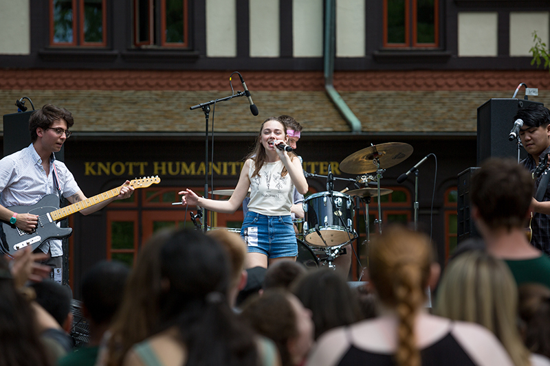 A singer performing on stage in front of an audience at Loyolapalooza