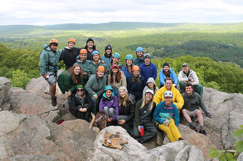 A group of students posing for a photo on top of a mountain after doing a hike through the Discovery program