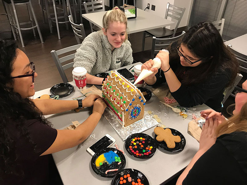 Students decorate a gingerbread house