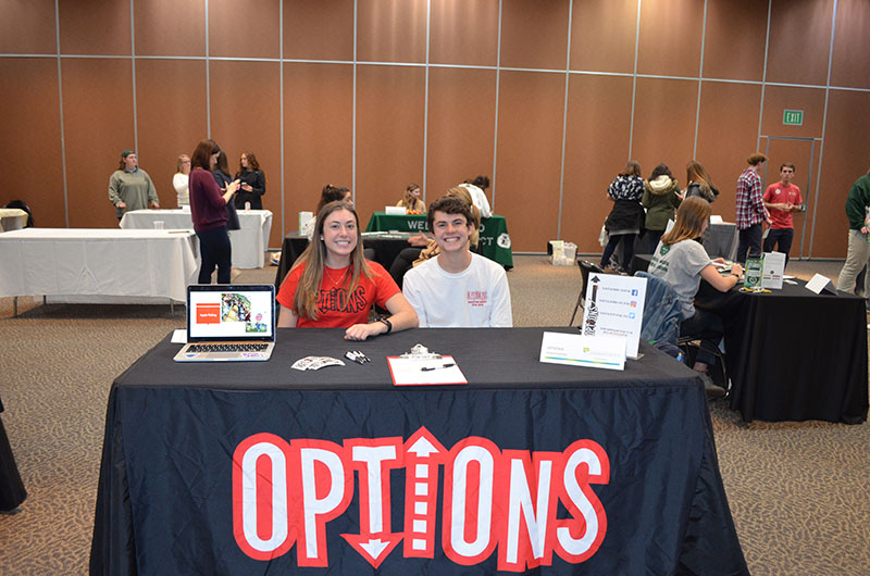 Two members of OPTIONS man a table in McGuire Hall