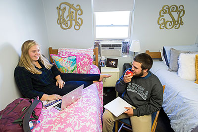 Two students hanging out in a dorm room