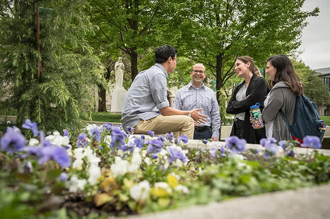 Professor speaking with students on the quad