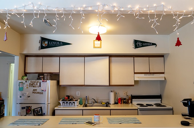 A decorated kitchen with Christmas lights and pennants in one of Loyola's residence halls