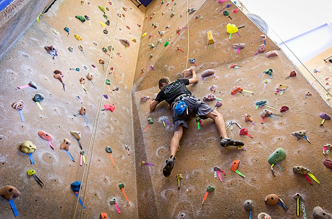 A student climbs the rockwall at the Fitness and Aquatic Center
