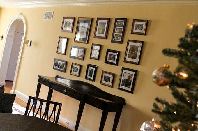 Loyola photos in picture frames hang on a tan wall, with a decorated Christmas tree in the foreground