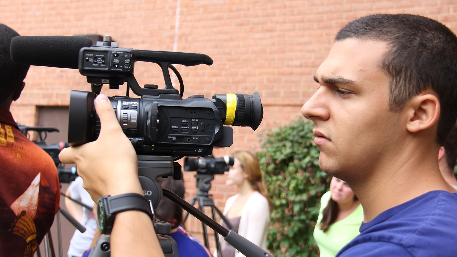 Close up shot of a student operating a video camera