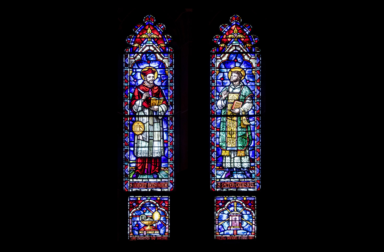 Two colorful stained glass panels of St. Robert Bellarmine and St. Peter Canisius
