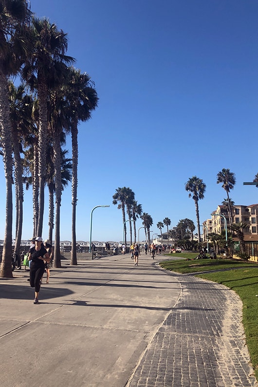 Pedestrians walking down the Pacfic Beach boardwalk