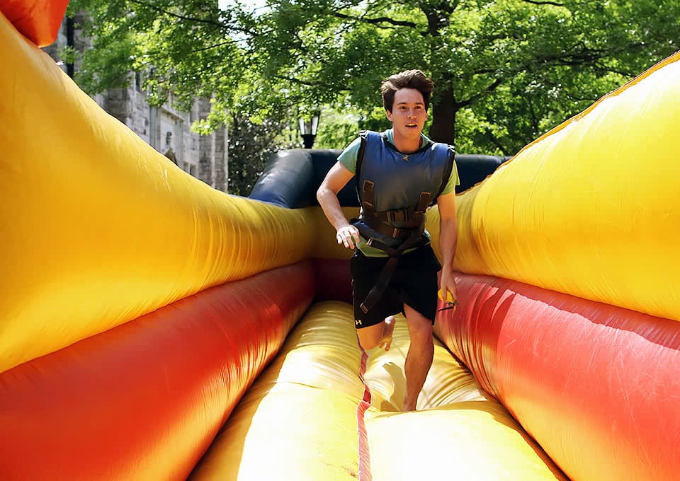 A student running on an inflated ride