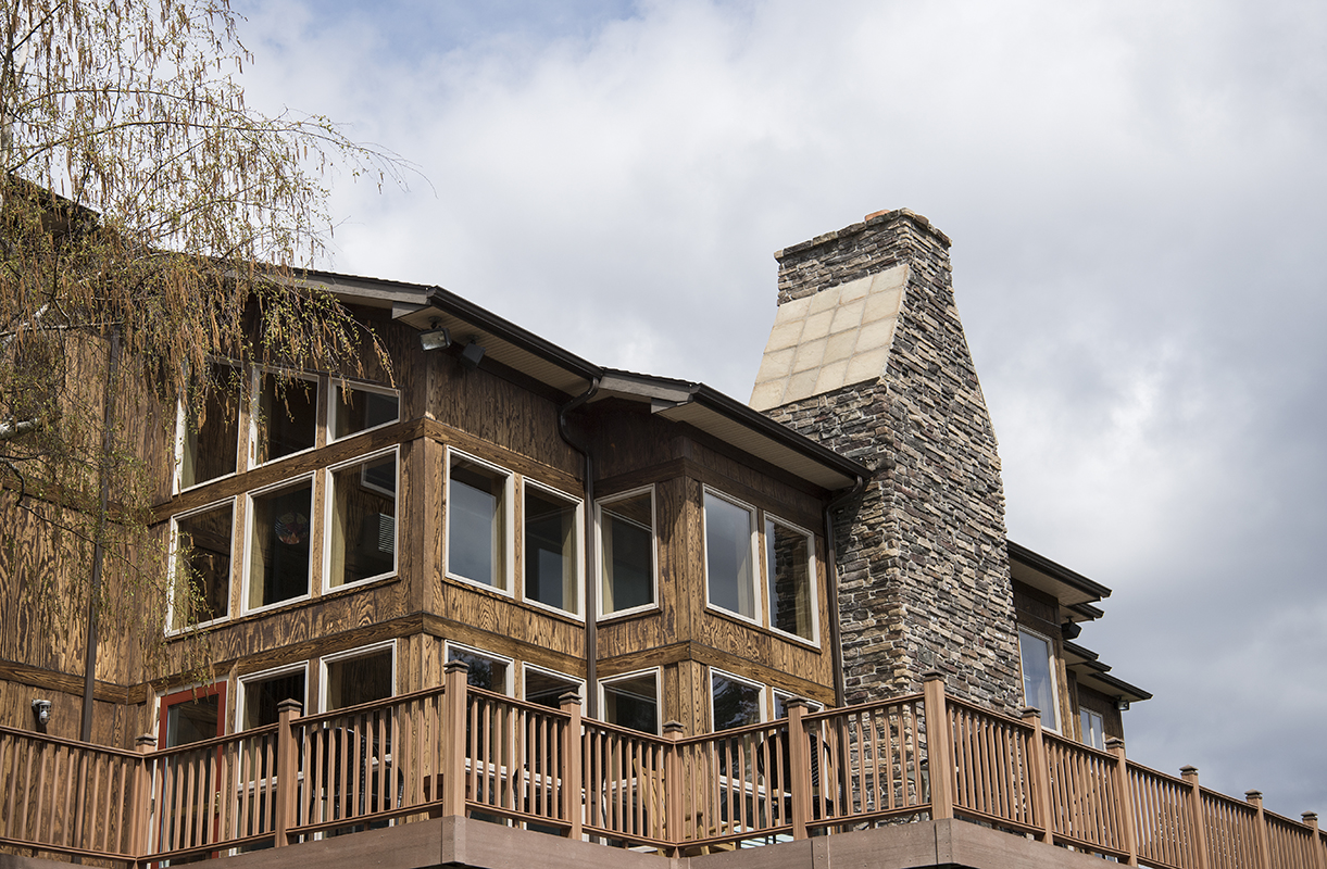 Retreat house with big stone chimney and great wooden porch.