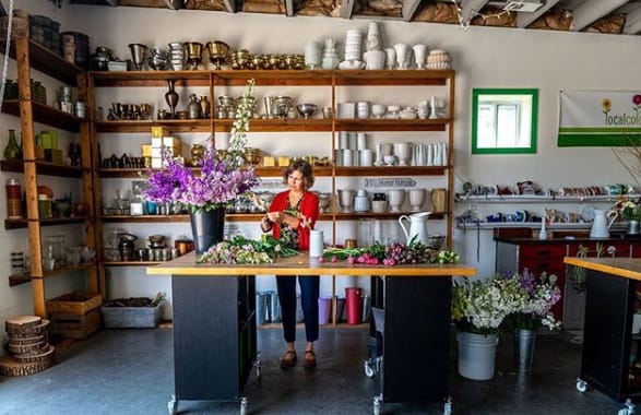 Ellen Frost working on flowers in the interior of her store, Local Color Flowers