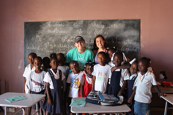 Julia and Ellie with Haitian students in classroom.