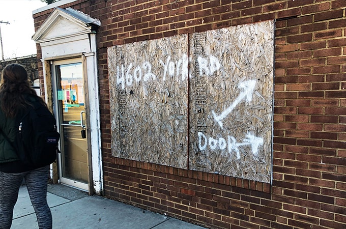 A storefront with a boarded up window