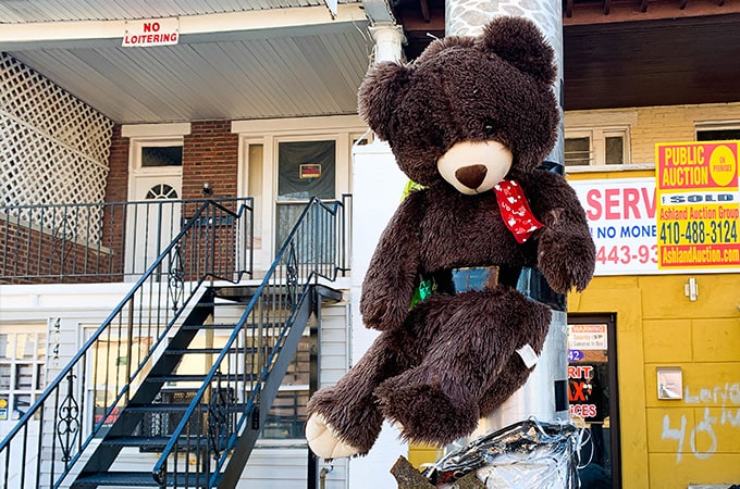 A teddy bear taped to a streetlight