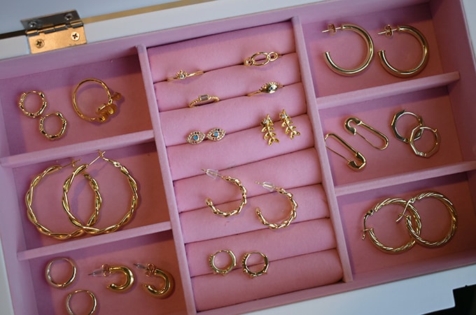 Various pieces of jewelry displayed in a pink jewelry box