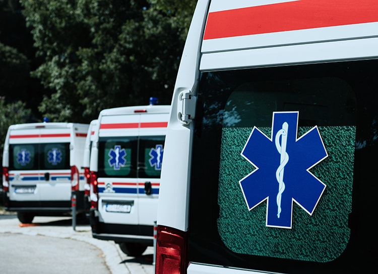 A series of three ambulances parked in a row