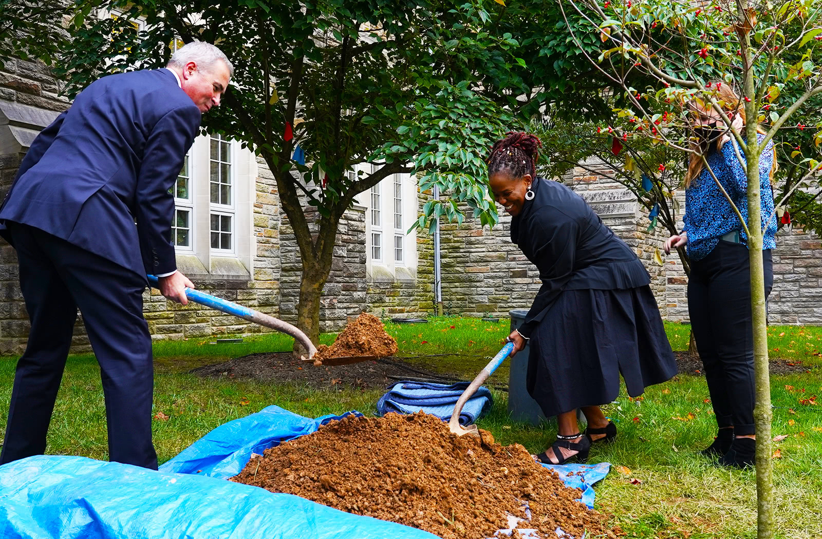 Terry Sawyer and Kaye Whitehead shovel dirt during a tree planting ceremony near the Fernandez Center