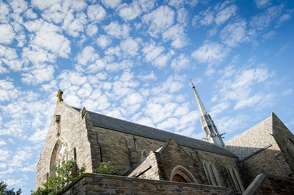 The Alumni Chapel exterior with a bright and cloudy sky above it