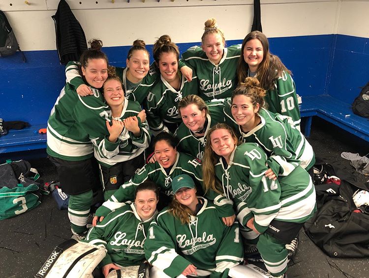 Loyola Women's Club Ice Hockey team smiling after a win.