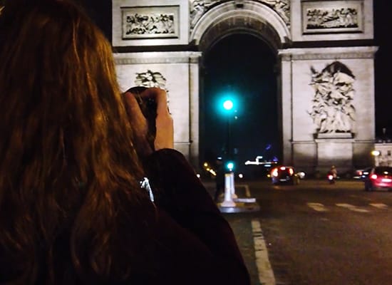 Student testing out lighting techniques while taking a photo of the Arc de Triomphe in Paris at night
