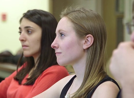 Two female students looking forward in a lecture classroom