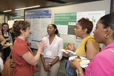 Faculty member in discussion with presenter and family at Emerging Scholars Loyola University