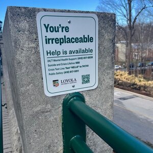 Suicide prevention sign nailed to Loyola bridge