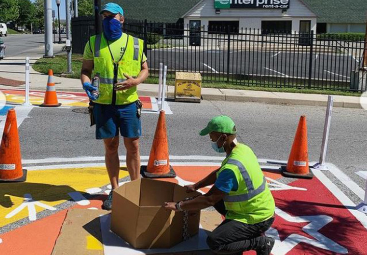 Volunteers painting the crosswalk art installation located along York Road