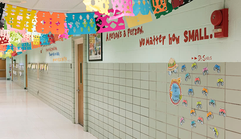 Hallway of a public school with the words 'A person's a person, no matter how small' on the wall