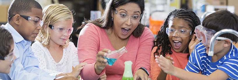 Instructor showing a science lab experiment to excited young children