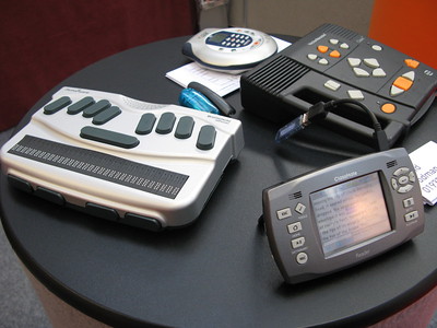 a round black table with four assistive technology devices