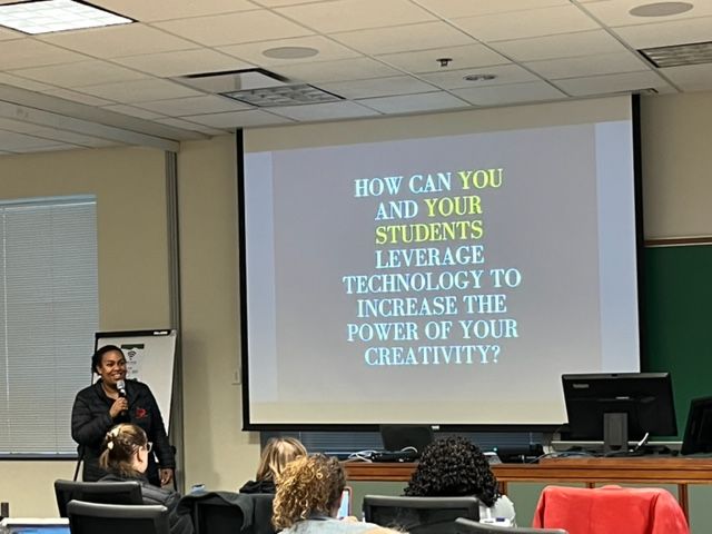 Woman speaking to an audience in front of a PowerPoint slide that says 'How can you and your student leverage technology to increase the power of your creativity?'
