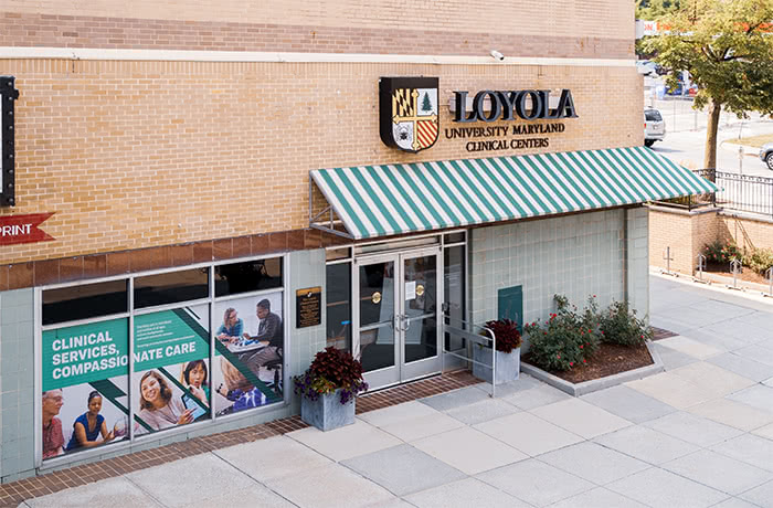 The entrance to Loyola's Clinical Centers in Belvedere Square featuring a striped awning and outdoor signage