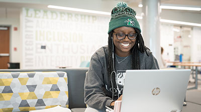 Student wearing a Loyola beanie while getting to know her peers in a remote class on her laptop