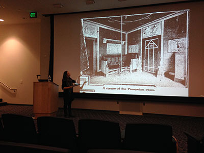 Marden Nichols presents near a projector screen