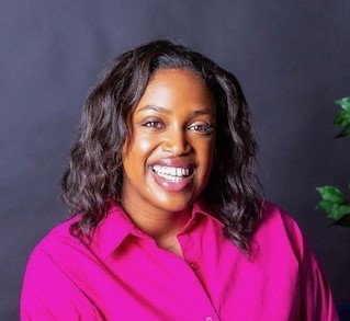 Joelle Hernandez, smiling in a bright pink blouse, is a member of Loyola University Maryland