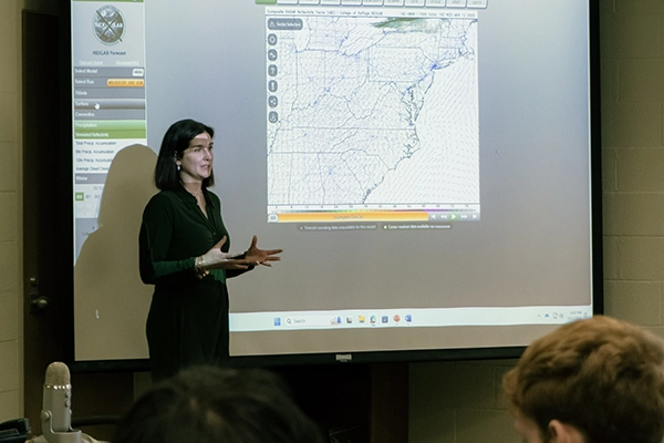 a professor shows a large map to facilitate class discussion